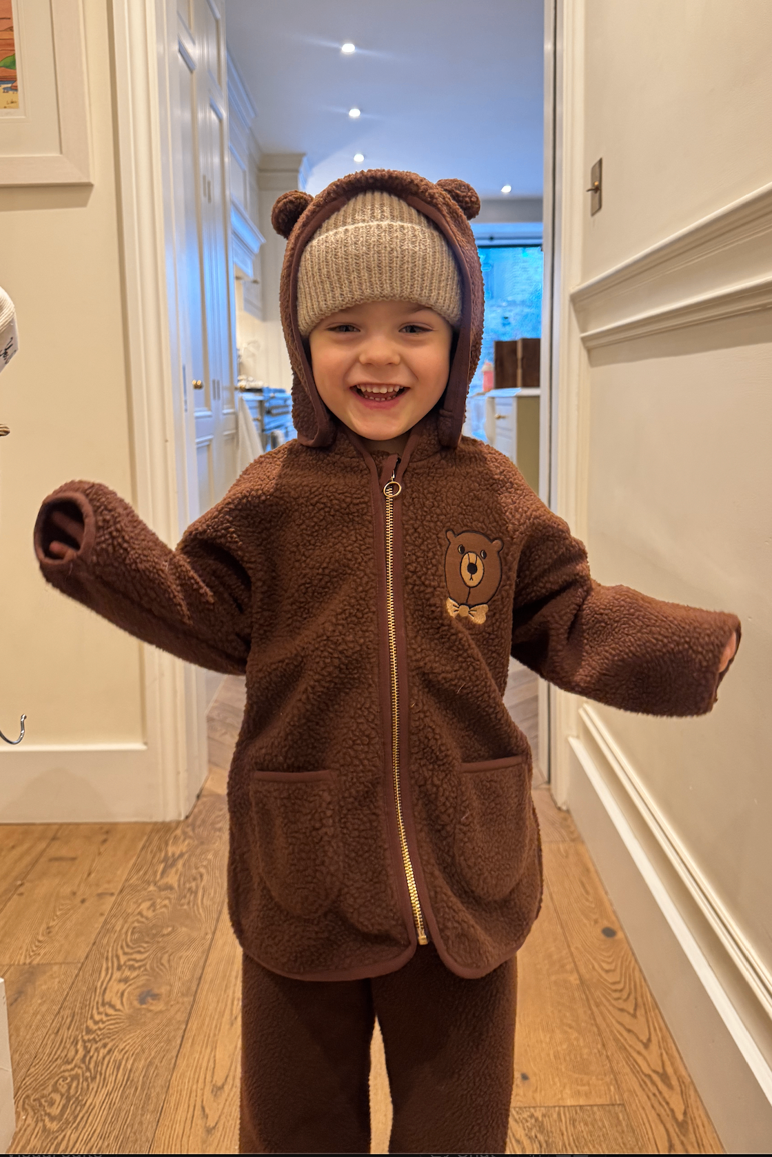 Leo, laughing, in a bear onesie